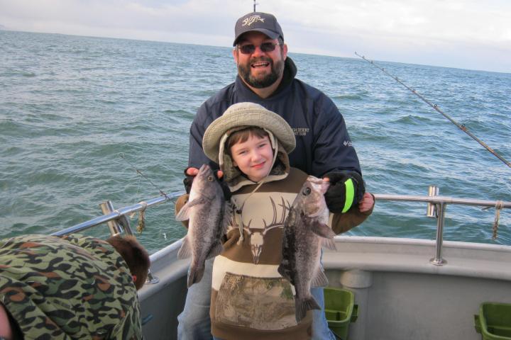 a person holding a fish on a boat in a body of water