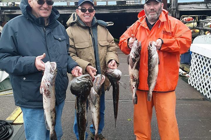 a group of people standing next to a person holding a fish