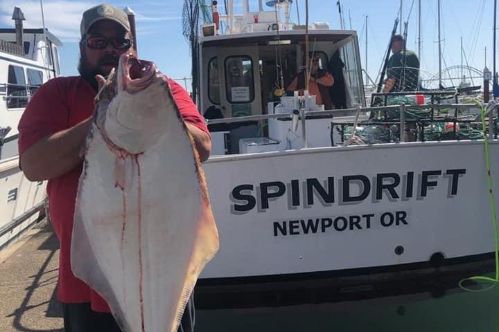 a person holding a fish on a boat