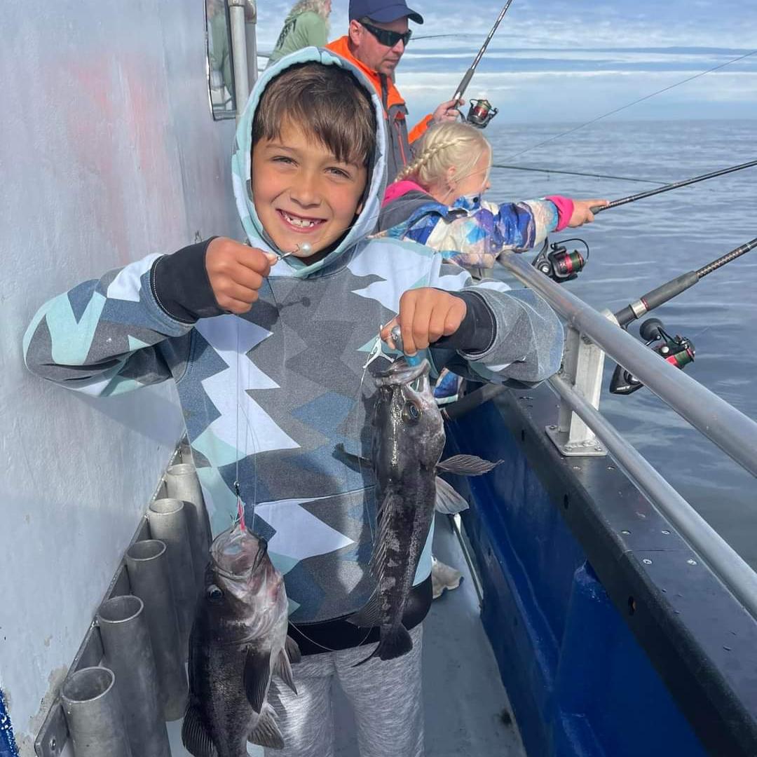 Little Boy with 2 Rock Fish Yaquina Bay Charters Little boy smiling holding up two rock fish on his line