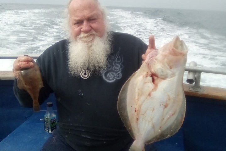 a person holding a fish on a boat in the ocean